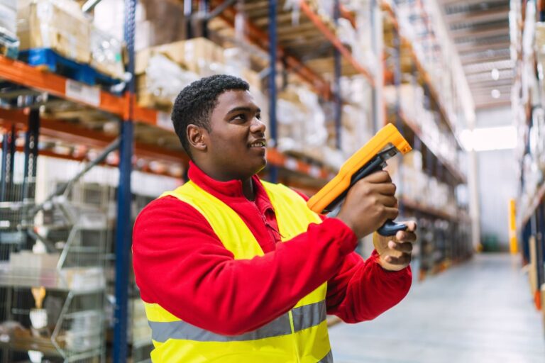 A Staples fulfillment center employee using a mobile scanner to manage inventory.