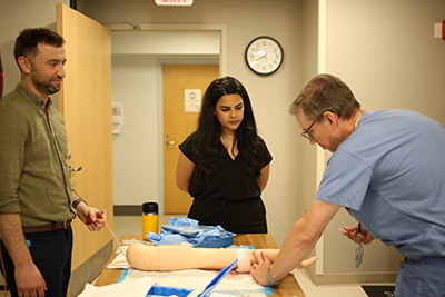 male medical provider demonstrating a procedure.