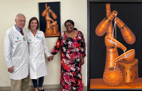 Pauline, right, with her physicians and the painting she gifted to them