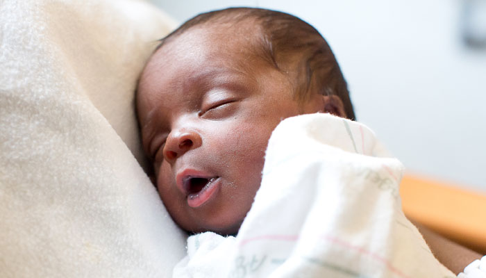 Newborn sleeping while being held
