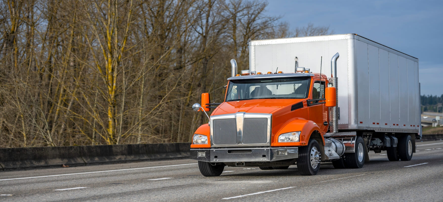 A straight truck driving on a city street.