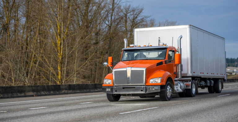 A straight truck driving on a city street.
