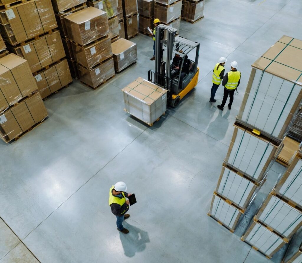 OLIMP's modern Milwaukee warehouse with tall pallet racks, workers scanning barcodes, and a forklift moving goods in a secure, well-organized facility."