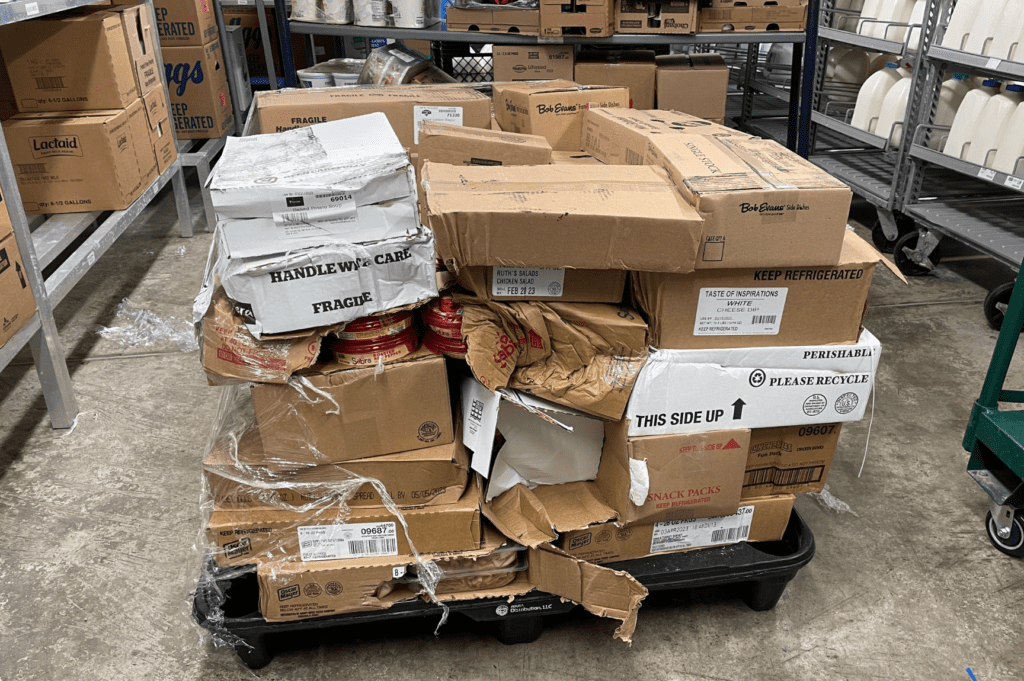 Damaged freight with collapsed pallets and shifted boxes requiring pallet rework services in Miami warehouse.