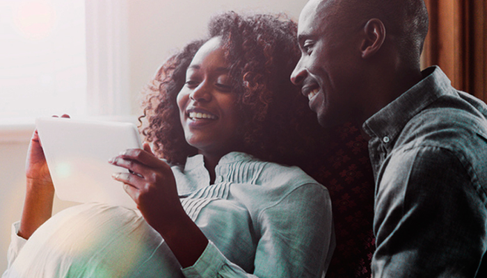man and pregnant women looking at tablet