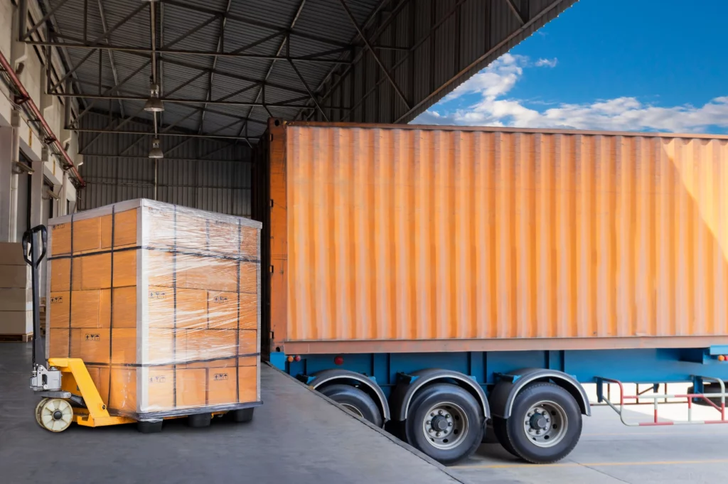 Import goods being sorted and reloaded between transportation modes at a U.S. transloading facility.